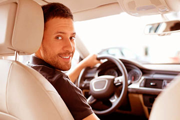 imagem de homem no volante do seu carro olhando para trás.