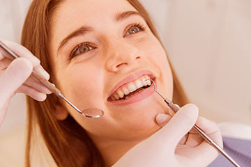 imagem de mulher sentada recebendo tratamento dentário